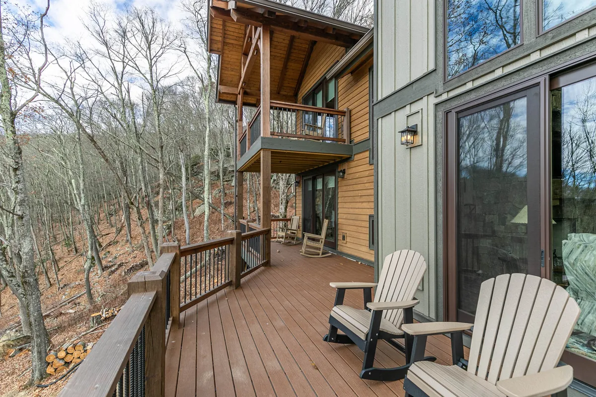 A wooden deck surrounded by trees, furnished with Adirondack chairs, and set for relaxing, reading, or enjoying nature. The peaceful setting suggests activities from morning coffee to stargazing and yoga.